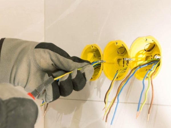 electrician-hands-mounting-electric-wall-receptacle-fitting-into-place_511010-3162